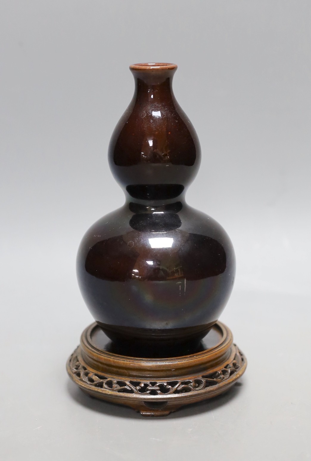 A Chinese brown monochrome double gourd vase (on stand). 19cm tall